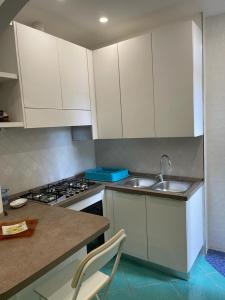 a kitchen with white cabinets and a sink at Ischia Dream Loft da Nancy in Ischia