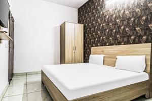 a bedroom with a bed and a wall with a mural at OYO Prime Property in Ludhiana