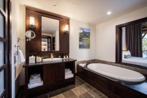 a bathroom with a tub and a large mirror at Nita Lake Lodge in Whistler