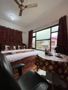 una camera da letto con due letti, un tavolo e una finestra di The Light House a Srinagar