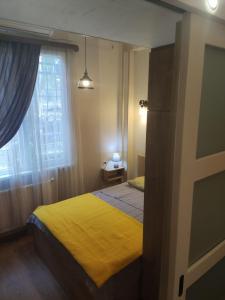 um quarto com uma cama amarela e uma janela em New apartment BARNABA close to Holiday Inn em Tbilisi