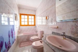 a bathroom with a sink and a toilet and a tub at Villa Teram in Alajeró