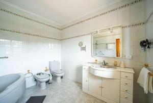 a bathroom with a tub and a toilet and a sink at Villa Teram in Alajeró +112 photos