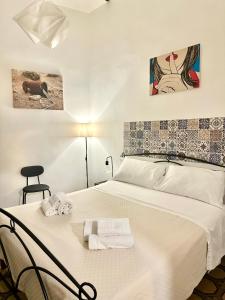 a bedroom with a large white bed with towels on it at A Casa di Luca in Conversano