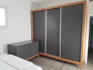 a bedroom with a dresser and a large glass closet at Bella Vista in Haifa in Haifa