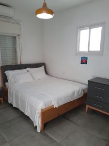 um quarto com uma cama grande e uma colcha branca em Bella Vista in Haifa em Haifa