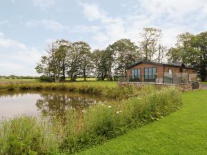 a house with a pond in front of it at Retreat By The Bowers in Preston