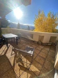 d'une table et d'une chaise sur un balcon bien exposé. dans l'établissement Charmant studio cabine 26m² avec belle terrasse, à Font-Romeu-Odeillo-Via