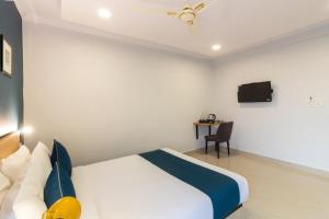 a hotel room with a bed and a tv at Silverkey Himayat Nagar Circle Near Snow World in Hyderabad