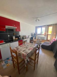 Il comprend une cuisine et un salon avec une table et des chaises. dans l'établissement Charmant studio cabine 26m² avec belle terrasse, à Font-Romeu-Odeillo-Via