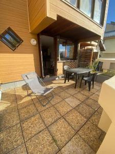 une terrasse avec une table et des chaises dans une maison dans l'établissement Charmant studio cabine 26m² avec belle terrasse, à Font-Romeu-Odeillo-Via