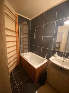 La salle de bains est pourvue d'une baignoire et d'un lavabo. dans l'établissement Charmant studio cabine 26m² avec belle terrasse, à Font-Romeu-Odeillo-Via