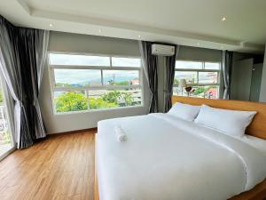 a large white bed in a room with windows at The White House Rachamankha - Adults Only in Chiang Mai +43 photos