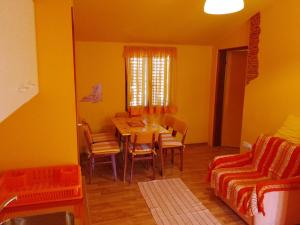 a dining room with a table and chairs and a couch at Apartments Velo in Veli Lošinj