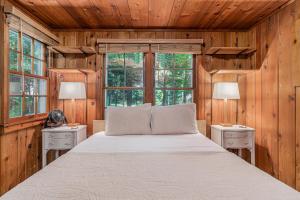 een slaapkamer met een bed met 2 nachtkastjes en 2 ramen bij Cottage Living in Beulah