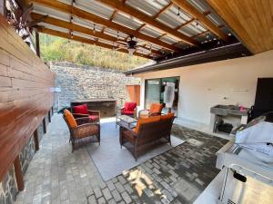 an outdoor patio with furniture and a stone wall at Casa Linda. Peaceful & Comfortable! in Atenas