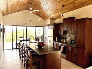 a large kitchen with a large island with wooden cabinets at Casa Linda. Peaceful & Comfortable! in Atenas