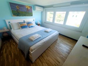 una camera da letto con un letto con pareti blu e due finestre di Celeste - affitti brevi a Polignano a Mare