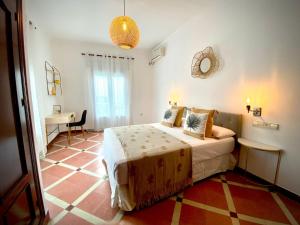 Casa Castelar by Bossh Apartments في روتا: غرفة نوم بسرير ومكتب في غرفة