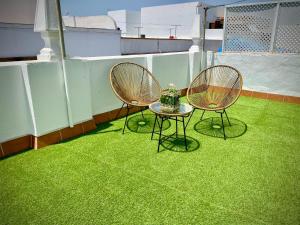 2 chaises et une table sur le toit dans l'établissement Casa Castelar by Bossh Apartments, à Rota