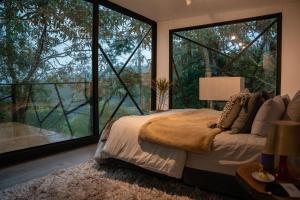 um quarto com uma cama e uma grande janela em ZIRUMA HOUSE em Santa Elena