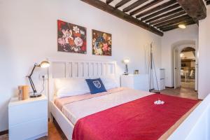 1 dormitorio con 1 cama grande con manta roja en Fabbrica: Two-wheeler lovers, en Peccioli