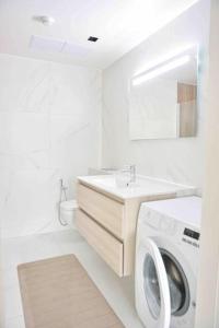 a white bathroom with a washing machine and a sink at Kalevi Panorama in Tallinn +18 photos