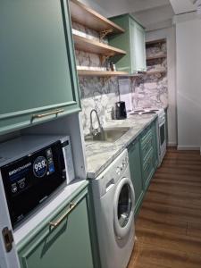 uma cozinha com uma máquina de lavar roupa e um lavatório em Коттеджи в ЦО “Радуга» em Chon-Sary-Oy