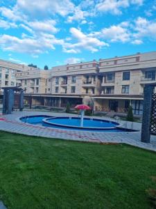 um grande edifício com piscina e guarda-sol em Коттеджи в ЦО “Радуга» em Chon-Sary-Oy