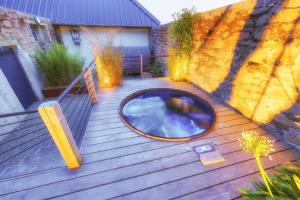 a small hot tub on a wooden deck at Domaine de Kerantroad in Plonévez-Porzay