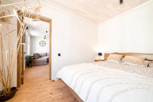 een witte slaapkamer met een groot bed en een bank bij Boutique apartment Mezrozite in Kuldīga