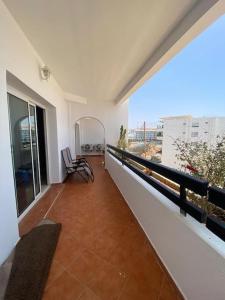 a balcony of a building with two chairs on it at Marina Agadir Comfy Apartment in Agadir