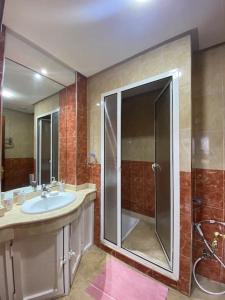 a bathroom with a sink and a glass shower at Marina Agadir Comfy Apartment in Agadir