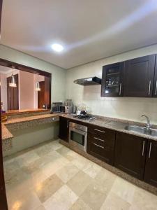 a kitchen with a sink and a stove top oven at Marina Agadir Comfy Apartment in Agadir