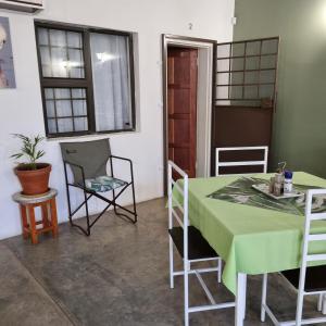 a dining room with a green table and chairs at Olienhoff Guesthouse in Otavi