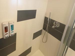 un bagno con doccia e piastrelle bianche e nere di Celeste - affitti brevi a Polignano a Mare