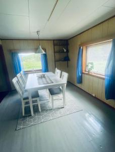 uma sala de jantar com uma mesa branca e cadeiras em Old vacation house em Skjåk