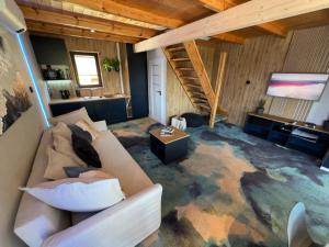 a living room with a couch and a tv at GooseHaus z prywatną sauną i jacuzzi in Gąski