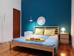 a blue bedroom with a bed with towels on it at Tradicional Portuguese Apartment in Lisbon