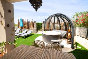 eine Terrasse mit Stühlen, einem Tisch und einem Pavillon in der Unterkunft Sunset sea view & garden Spa Cala Tarida 6p max in Cala Tarida