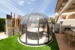 a glass dome on a lawn in a yard at Sunset sea view & garden Spa Cala Tarida 6p max in Cala Tarida