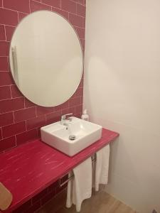 W łazience znajduje się biała umywalka i lustro. w obiekcie Casuca Rubia w mieście Bosquemado