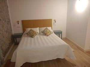 ein Schlafzimmer mit einem Bett mit zwei Kissen darauf in der Unterkunft Casuca Rubia in Bosquemado
