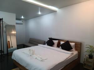 a bedroom with a bed with two towels on it at Nimman 9 in Chiang Mai