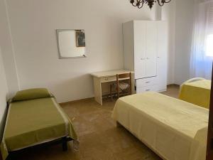 a bedroom with two beds and a dresser and a mirror at DodoHouse2 in Amandola