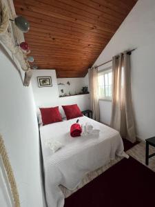 a bedroom with a bed with a red stuffed animal on it at Aloxamento A Mariña in Oia