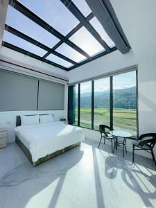 a bedroom with a bed and a table and chairs at 遇見 雲山居 in Fuli