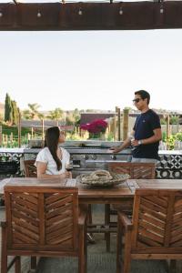 mężczyzna i kobieta siedzący przy stole w obiekcie Sol del Valle w mieście Valle de Guadalupe