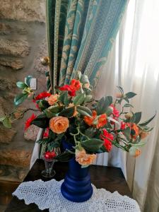 niebieska waza wypełniona kwiatami na stole w obiekcie ROSAS DA GRANJA - CASA DE CAMPO w mieście Granja