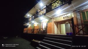 a building with stairs and lights in the dark at OYO Kamal Guest House Tirthan in Banjār